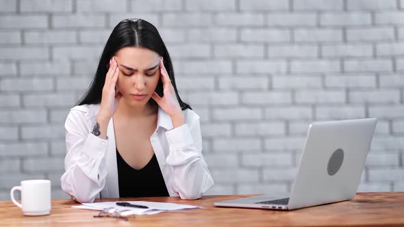 Young Asian Businesswoman Suffering Headache at Workplace