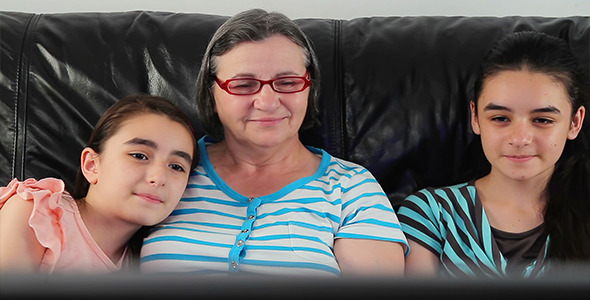 Senior Woman and Girls Watching Television