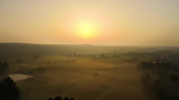 Aerial Landscape View of Sunny Morning Over Foggy Green Fields