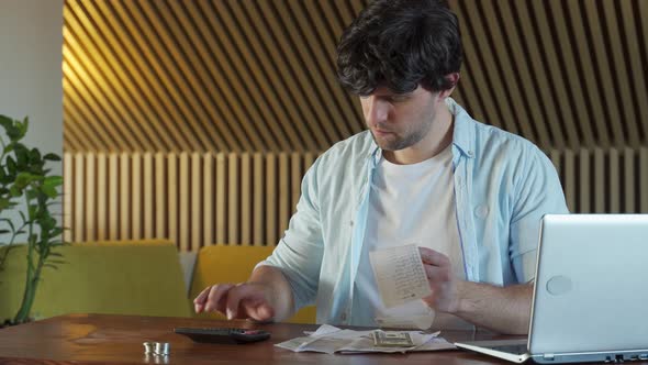 Smiling Young Man Analyzing His Expenses and Paying Online