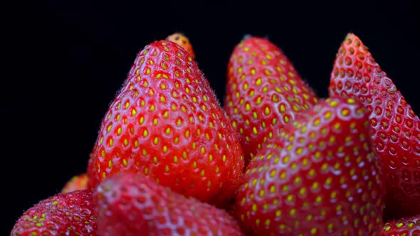 Strawberries without tails lie in white bowl or plate. It rotates