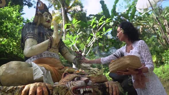 Woman Offering Flowers to Buddhism Sculpture Outdoors Tropical Nature Around Sacred Religion Temple