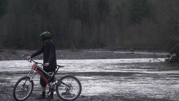 A young man mountain biking in a forest on a mountain.