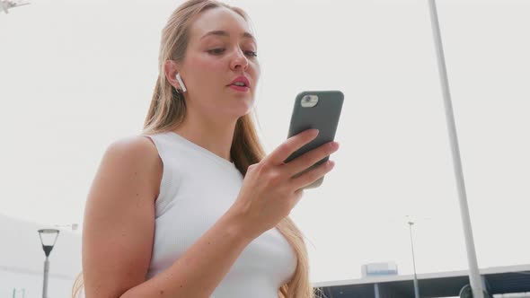 Young woman outdoor using smartphone listening music