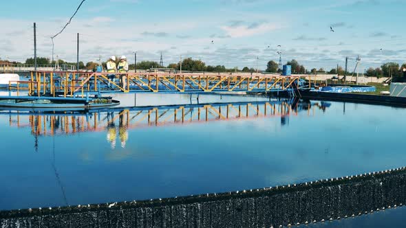 Wastewater Operators Inspecting a Circular Clarifier in Daylight