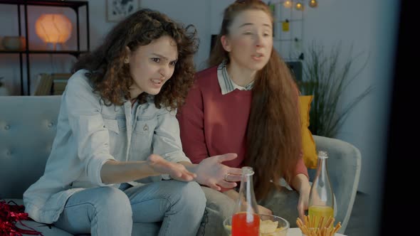 Nervous Young Women Watching Sports Game Cheering Expressing Disappointment at Home at Night