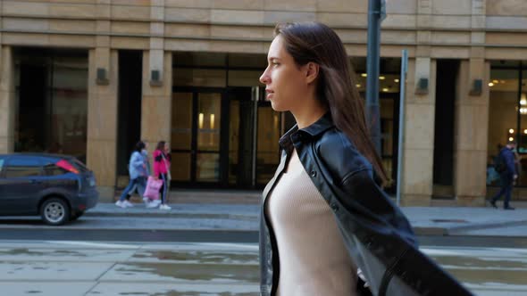 Confident Woman in Leather Jacket Walking Street