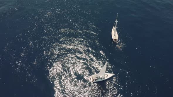 Aerial View of Two Yachts in the Ocean Silhouettes of Swimming People Next to Yachts