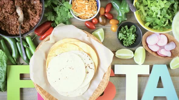 Ground beef tacos with romaine lettuce, diced tomatoes, radishes, and shredded cheddar cheese.