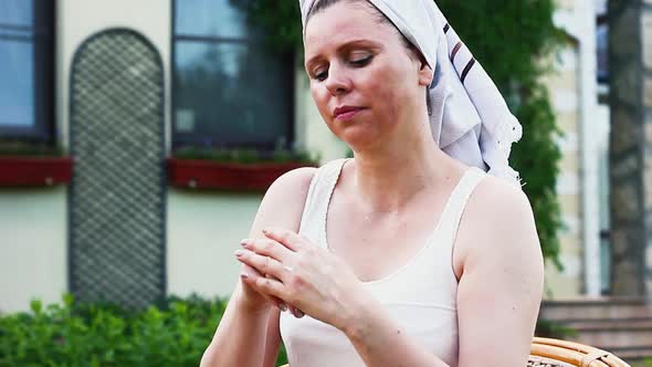 Middle Aged Caucasian Ethnicity Woman Applying Antiaging Cream Outdoors