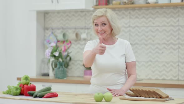 Old Woman Showing Thumbs Up While Standing in Kitchen