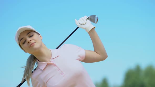 Woman Golfer Bending Sides With Club on Shoulders Warming Up Back Muscles