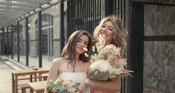 Elegant Women with Bouquets Posing in the City