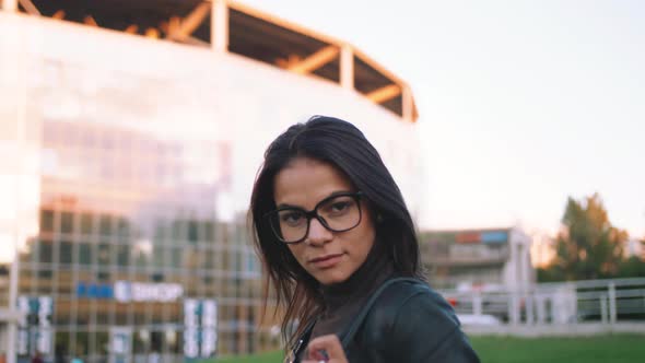 Portrait of Young Stylish Woman in Glasses Outside on Urban Background