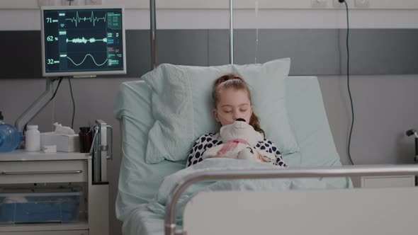 Portrait of Hospitalized Sick Child Falling Asleep While Holding Teddy Bear in Hands