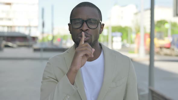 African Man Putting Fingers on Lips Quiet Sign