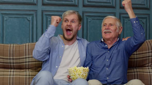 Senior Grandfather and Young Men Watching Football Match on Television Males Generations Family