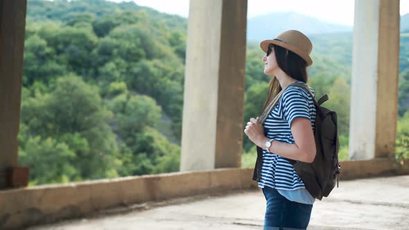 Young Female Traveler with Backpack Looking Into the Distance in Ancient City