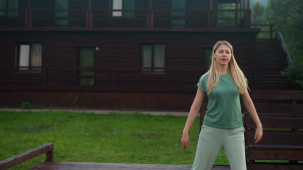 Woman in Sportswear Does Sidesteps on Ground Near Hotel