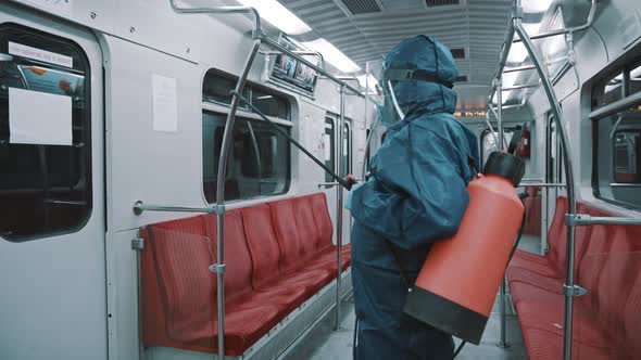  Infection Prevention and Control of Epidemic. Man in Protective Suit Spraying Train