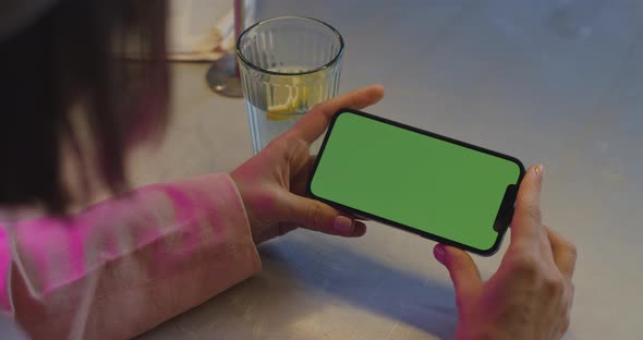 Woman Holding Cell Phone and Tapping on Chroma Key Screen