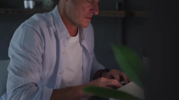 Man using computer at home at night