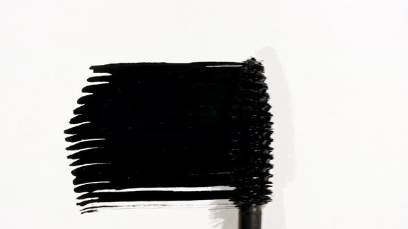 Macro Shot and Slow Motion of a Black Mascara Isolated on White Background