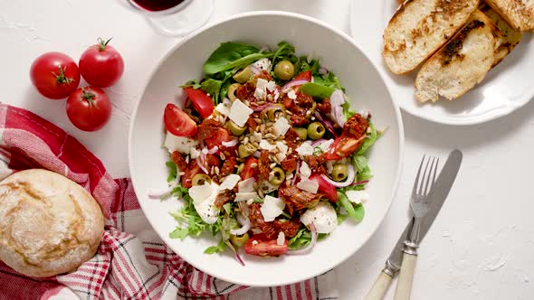 Tasty Dried Tomatoes Salad with Fresh Vegetables Mix and Mozzarella Cheese Served with Toasts