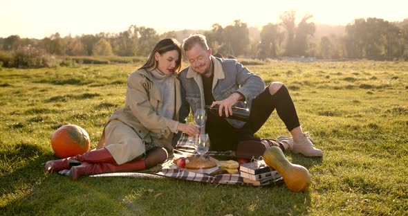 Couple Enjoying Red Wine on a Picnic in Nature