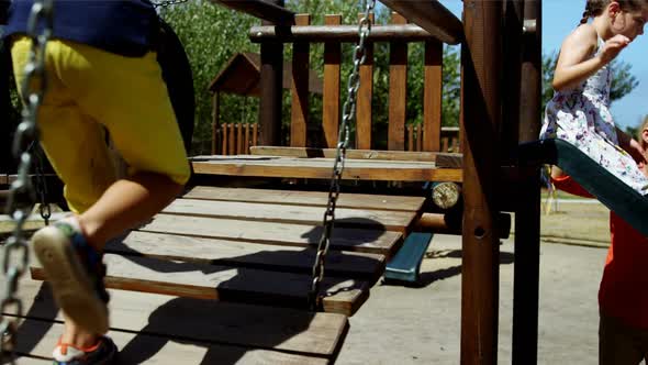 Trainer assisting schoolkids while playing in playground