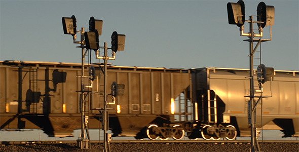 Freight Train Passing Railroad Signals at Sunset