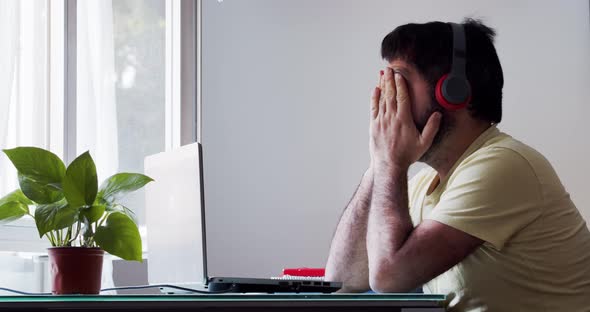 Spanish Man with Beard Working at Home Disappointed and Tired