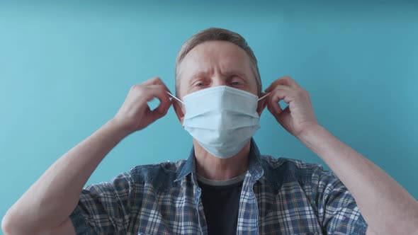 An Elderly Man Takes Off Surgical Mask