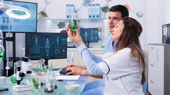 Bio Researcher Looking at Samples and Talking with Her Assistant