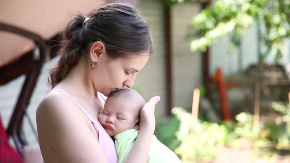 Little Baby Boy Sleeping on Mom's Chest Outdoor