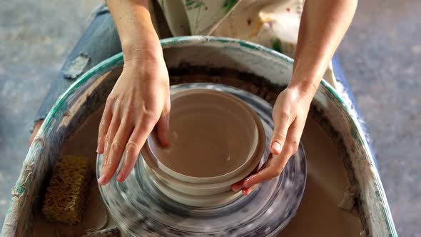Hands of female potter making a pot