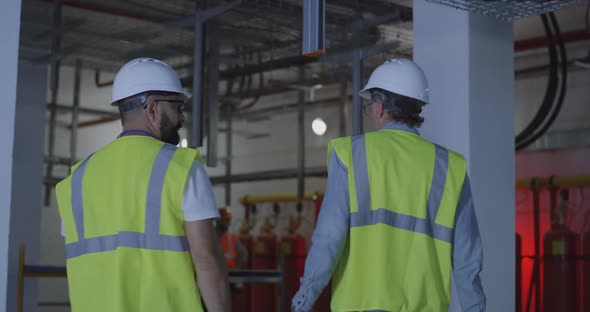 Male Contractors Examining Insides of Power Station