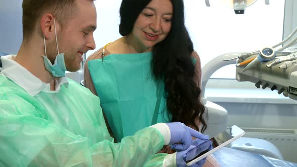 Dentist Explaines To the Client Something on His Tablet