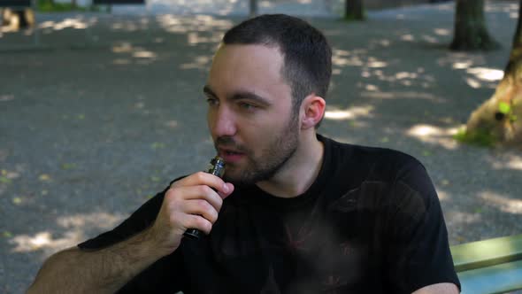 Man Smoking the Vape Outdoors.