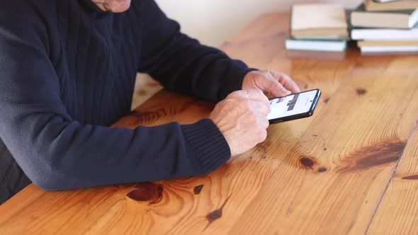 Smiling Old Man Using Smartphone While Sitting on Couch