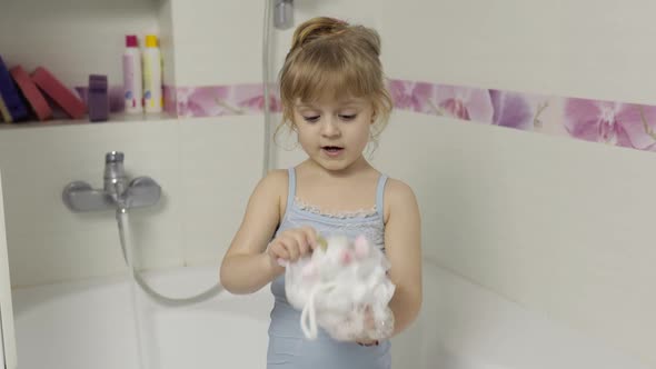 Cute Blonde Girl Takes a Bath in Swimwear. Little Child, 4 Years Old. Hygiene