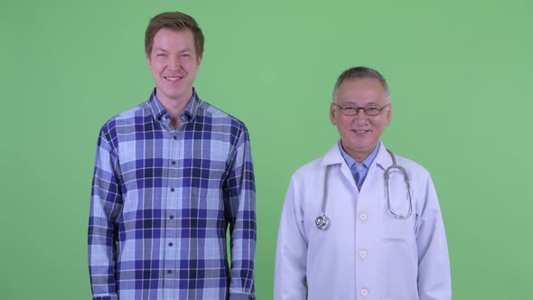 Happy Mature Japanese Man Doctor with Young Man Smiling Together