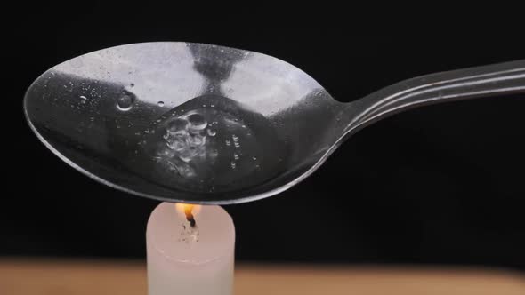 Cooking Drugs in a Spoon on a Candle Flame