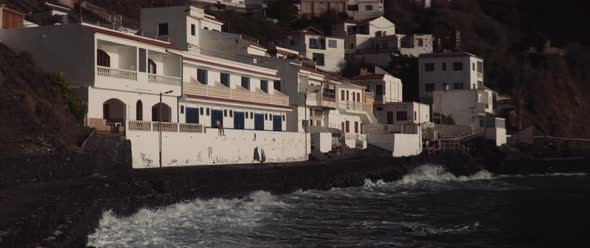 Young man sitting on the balcony edge staring at the sea