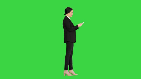 Casual Female in a Suit Texting on Her Phone on a Green Screen, Chroma Key.