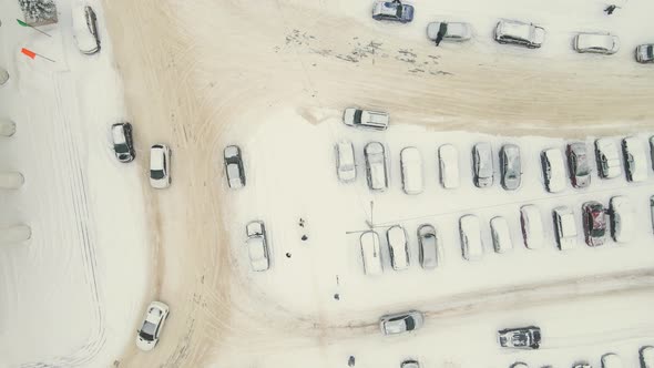 Cars Go Slowly Alongside a Snowcovered Parking Lot After a Heavy Snowstorm