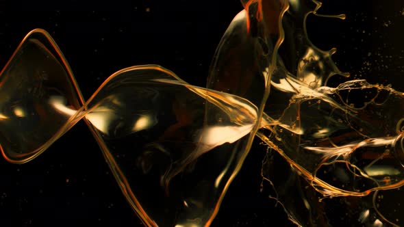 Super Slow Motion Shot of Swirling and Splashing Golden Oil Isolated on Black Background at 1000Fps