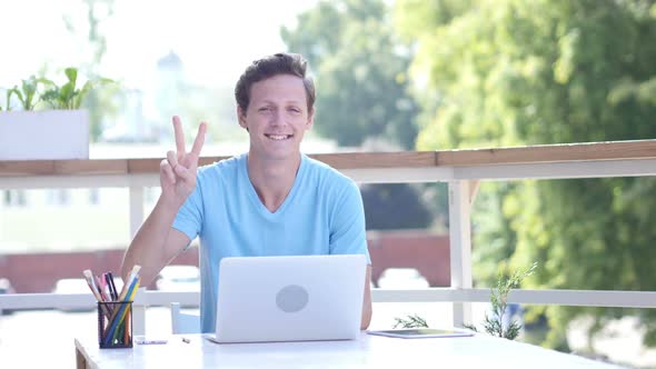 Sign of Victory by Confident Young Man, Best in Business