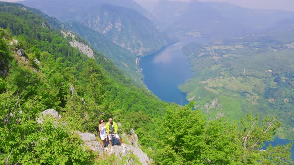 Aerial View on Couple Standing Against Amazing Nature View on Mountain Lake in on the Border of