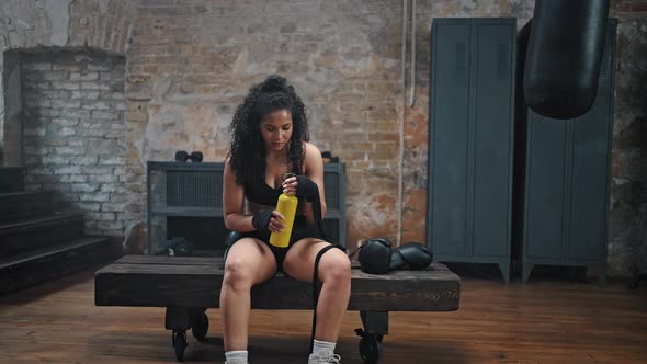 Exhausted Woman Takes Break on Pommel Horse Drinking Water